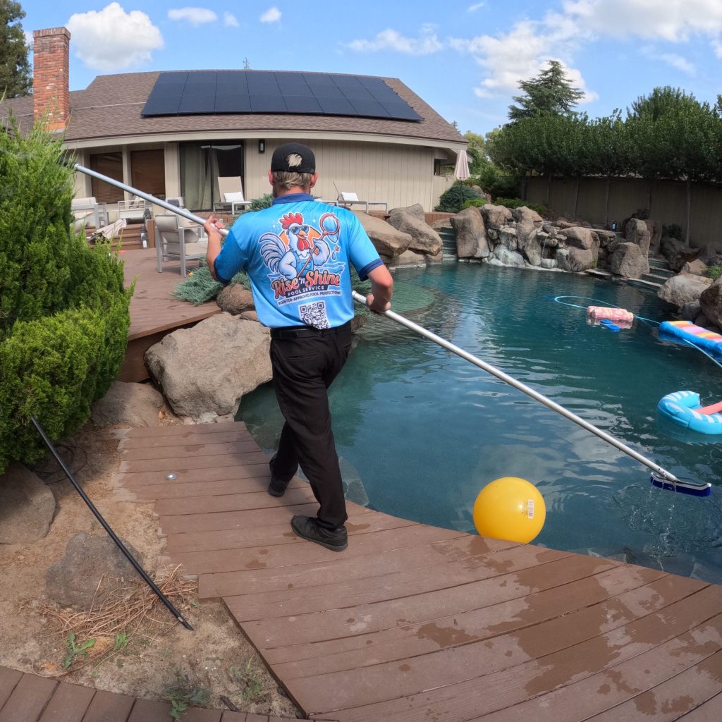 Pool service technician cleaning a residential pool in Modesto California